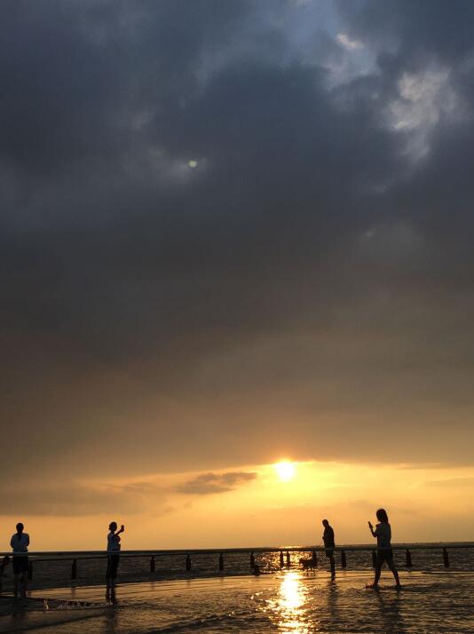 夏日湖水上涨，夕阳下游客嬉闹